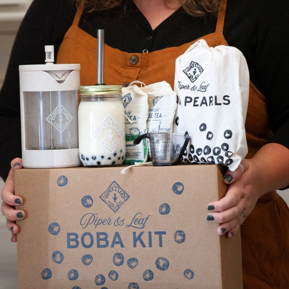 A woman holding a box with a Piper & Leaf Tea Co. Boba Tea Kit.