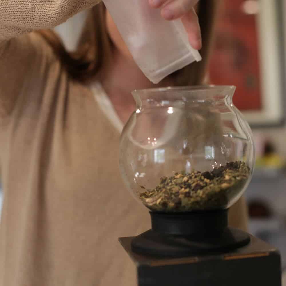 Pouring a full bag of loose leaf into a Tea Dripper strainer to make concentrated tea