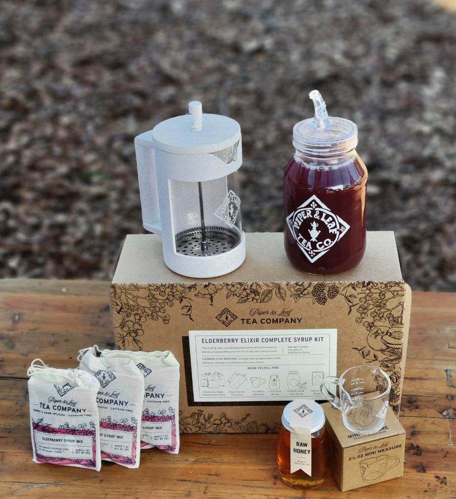 A Piper and Leaf Tea Co. Elderberry Elixir Complete Syrup Kit box containing a bottle of Elderberry Elixir Syrup.