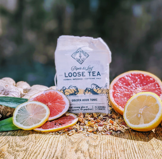 A Golden Hour Tonic Muslin Bag of Loose Leaf Tea - 15 Servings flavored with ginger on a wooden table from Piper & Leaf Tea Co.