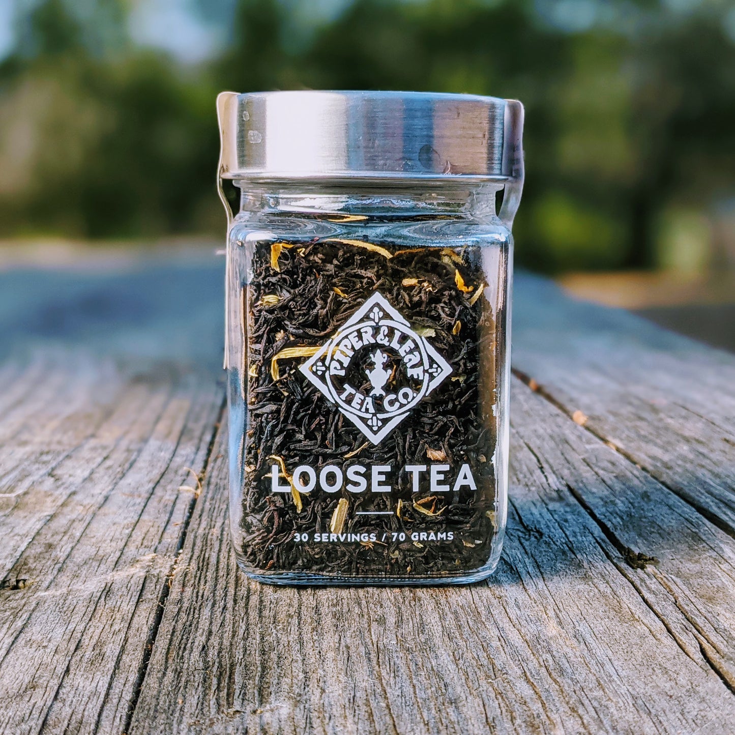 Monks Meditation Glass Jar of Loose Leaf Tea - 30 Servings filled with loose catnip leaves on a wooden surface outdoors from Piper & Leaf Tea Co.