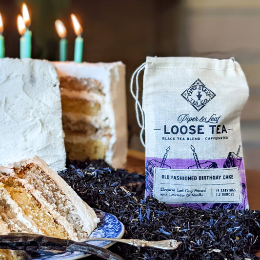 A Piper & Leaf Tea Co. cake with candles and a bag of Old Fashioned Birthday Cake Muslin Bag of Loose Leaf Tea - 15 Servings breakfast tea.