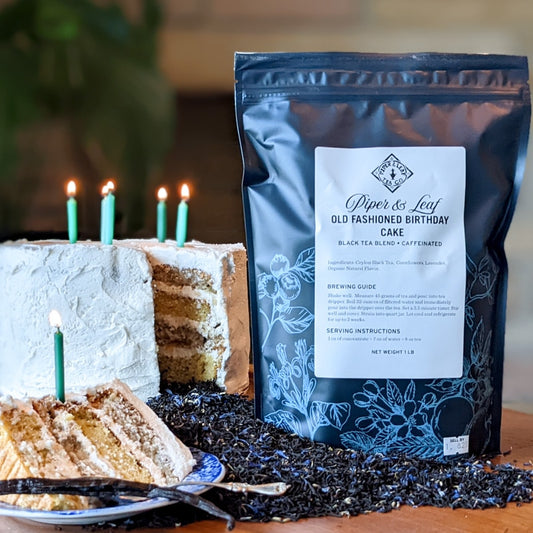 A piece of Old Fashioned Birthday Cake Pound Bag with candles next to a bag of rich coffee from Piper & Leaf Tea Co.