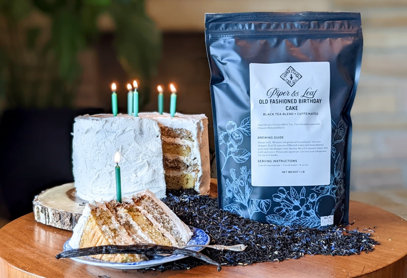 A Old Fashioned Birthday Cake Pound Bag - 190 servings with candles on a table next to a bag of coffee.