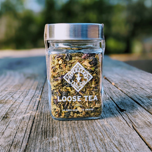 A Piper Mint Blues Glass Jar of Loose Leaf Tea - 30 Servings from Piper & Leaf Tea Co. sitting on a wooden table.