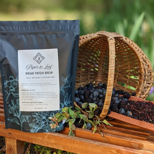 A basket of berries next to a Briar Patch Brew Pound Bag of blueberry tea concentrate from Piper & Leaf Tea Co.