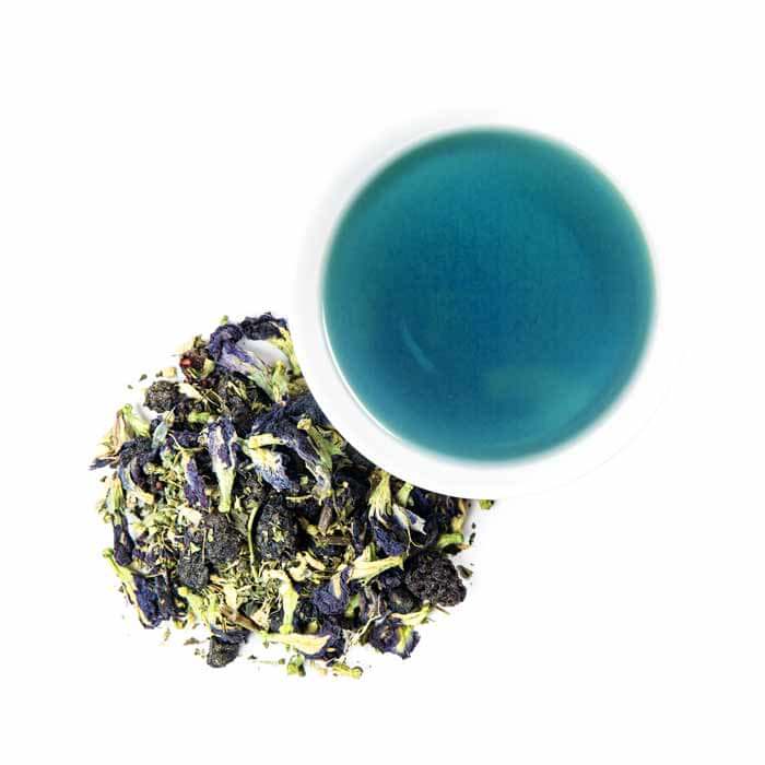 Piper Mint Blues loose leaf next to a cup of brewed tea: bright blue