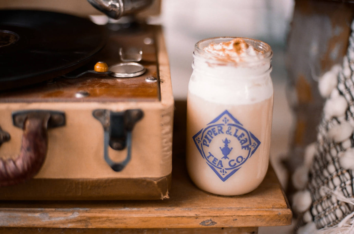 An iced milk tea topped with whipped cream and cinnamon in a pint jar