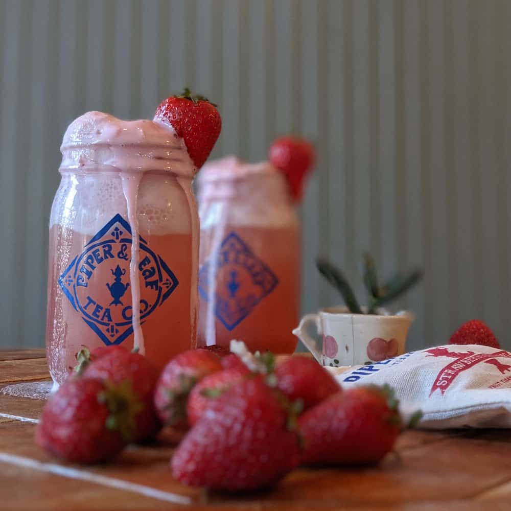 Pint mason jars with delicious sparkling Strawberry Shindig ice cream floats, surrounded by fresh strawberries