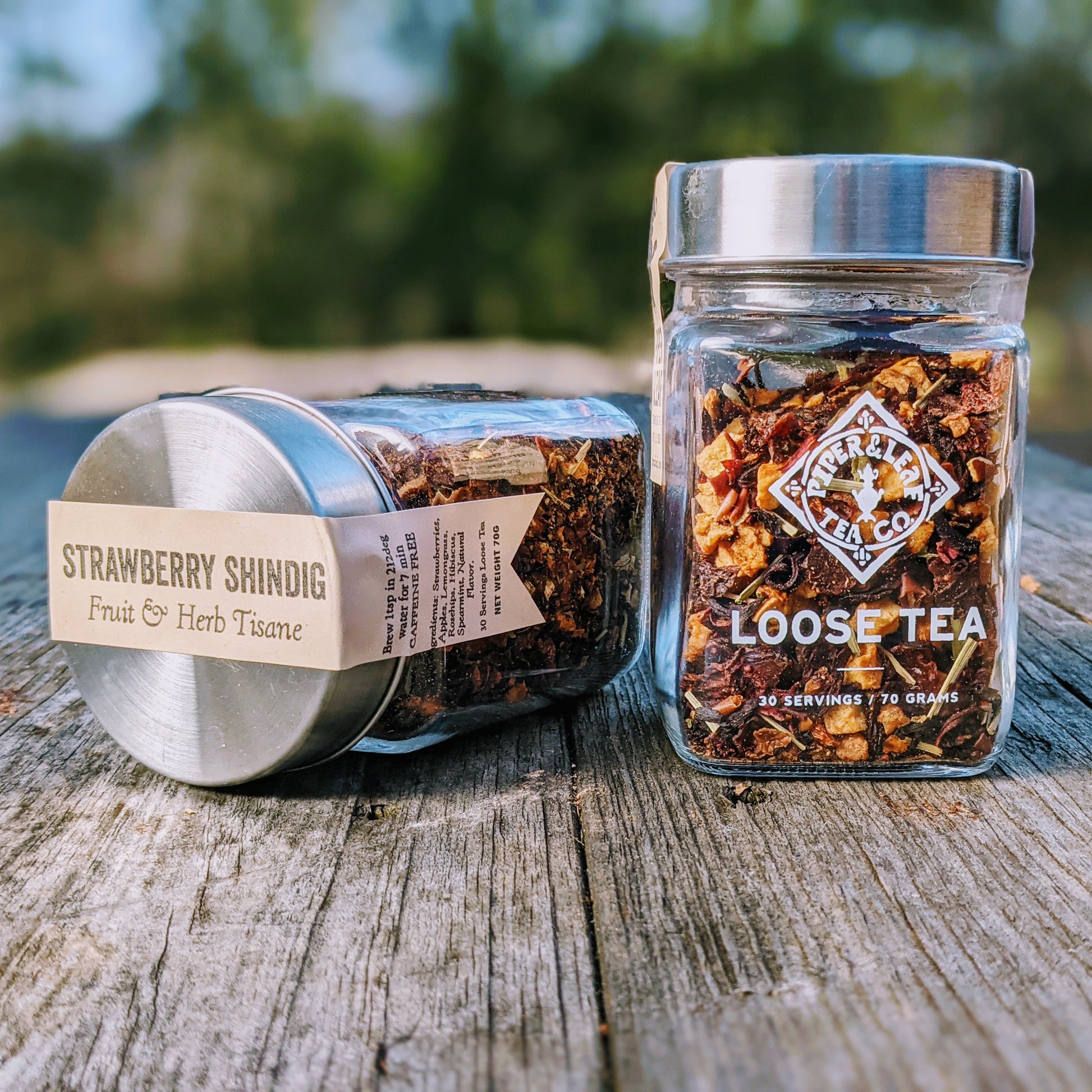 A jar of Strawberry Shindig Glass Jar of Loose Leaf Tea - 30 Servings by Piper & Leaf Tea Co. sitting on a wooden table.
