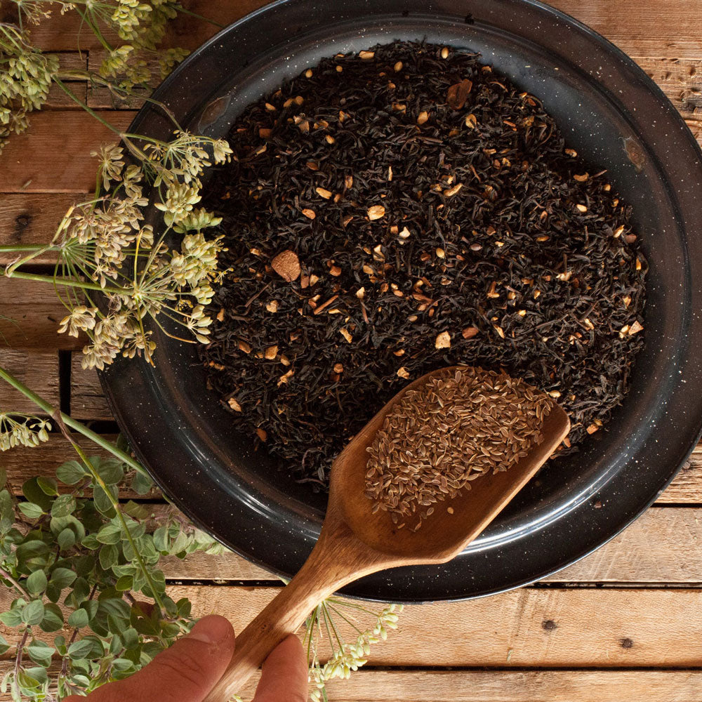 A mixing bowl combining spices and black tea together for Summertime Chai