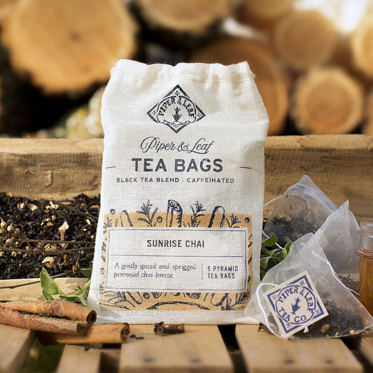 A bag of Piper & Leaf Tea Co.'s Sunrise Chai 9ct Tea Bags in Muslin sitting on a wooden table.