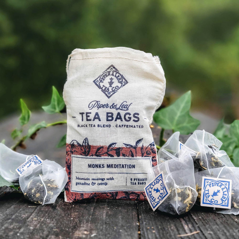 A canvas bag of Piper & Leaf Tea Co.'s Monks Meditation 9ct Tea Bags in Muslin with loose tea bags displayed in front.