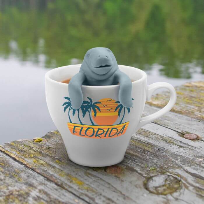 A manatee shaped Fred-brand tea strainer in a Florida mug