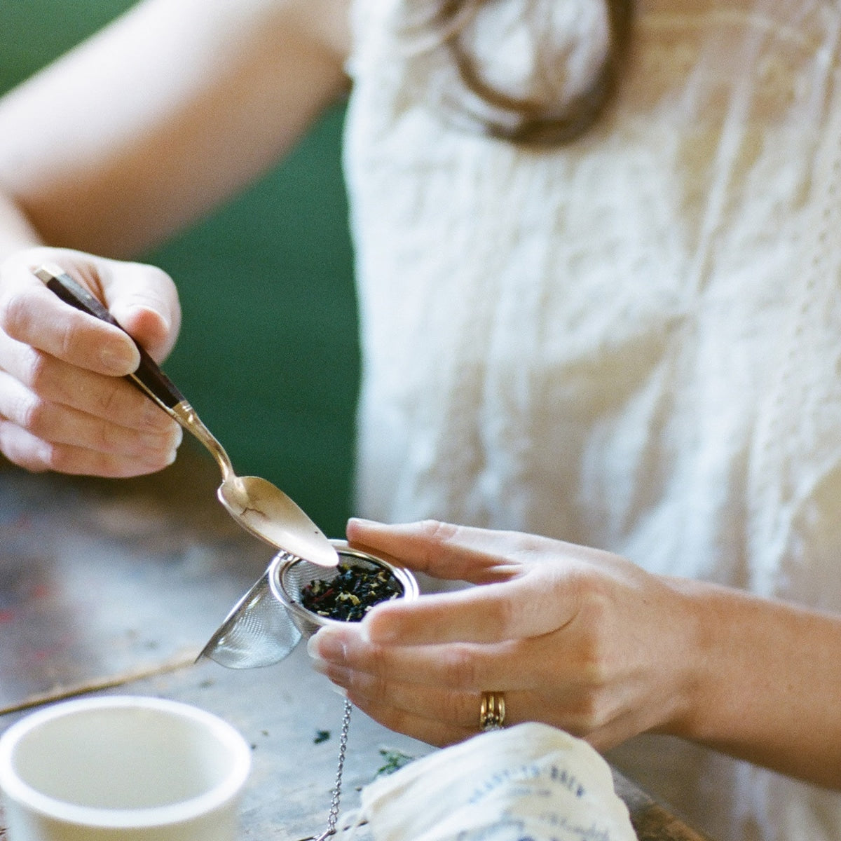 Scooping loose leaf into a tea ball to brew a tea