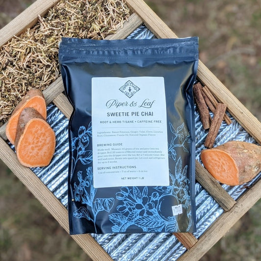 A Sweetie Pie Chai Pound Bag - 190 servings from Piper & Leaf Tea Co. atop a wooden crate, exuding a hint of creamy clove and cinnamon aromas.
